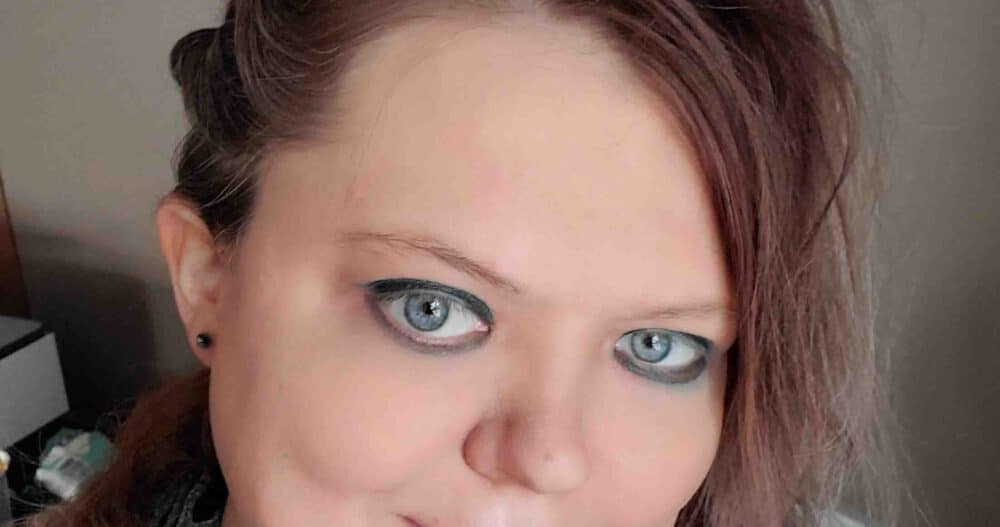 Headshot of a woman with brown hair and blue earrings.