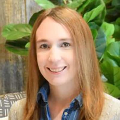 Headshot of a smiling woman with red hair.