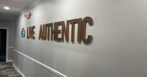An Ellie Mental Health clinic with "LIVE AUTHENTIC" and the Ellie Mental Health logo on the wall.