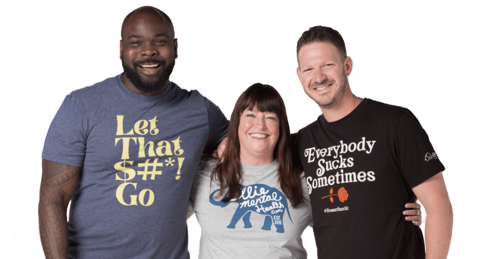 Three Ellie Mental Health professionals standing together wearing graphic t shirts with various messages like "Let That $#*! Go, Everybody Suck Sometimes, and Ellie Mental Health.com