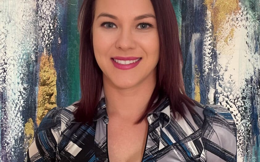 Headshot of Christy Martin, LAC, dressed in black, white, and gray top.