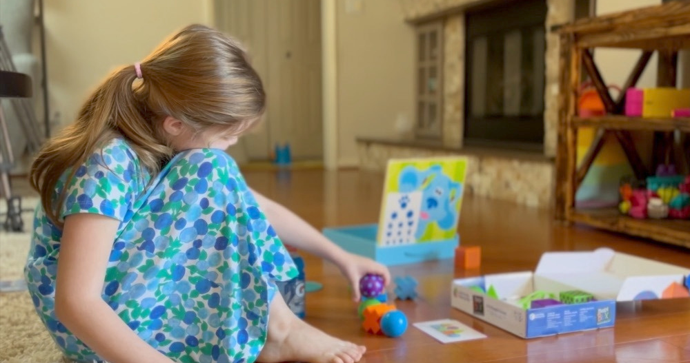 Girl sitting in her house playing on the floor